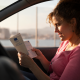 Donna legge la carta di circolazione in auto